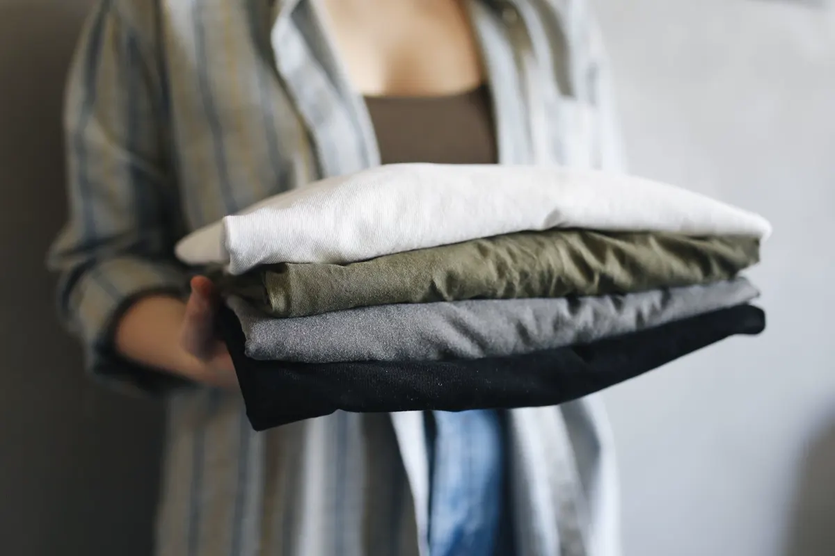 Pile de vêtements propres et pliés tenue à deux mains